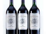 three bottles of wine are lined up on a white surface