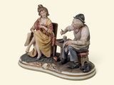 a figurine of a man and a woman sitting on a chair