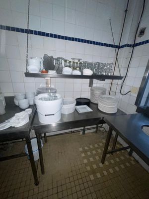 une cuisine avec un évier et un comptoir sur lequel se trouve de la vaisselle