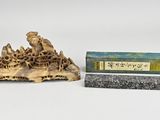 an image of a small statue of a man on a rock next to a box of incense