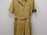 a brown shirt dress hanging on a wall next to a hanger