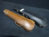 a violin case and a violin case on a black surface
