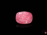 a picture of a pink stone on a black surface