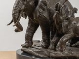 a statue of an elephant and two baby elephants on a table