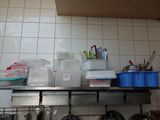 a shelf with pots and pans on it in a kitchen