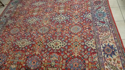 une photo d'un grand tapis oriental posé sur le sol d'une pièce