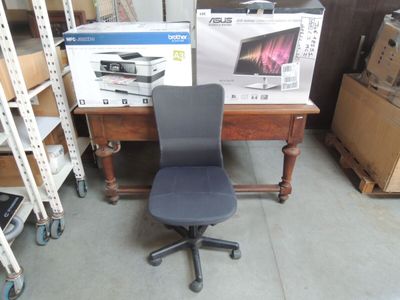 a black office chair sitting in front of a desk