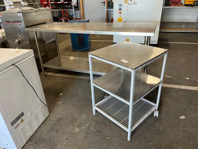 une table en métal avec une étagère en métal au milieu de la pièce