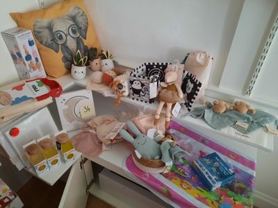 une petite table sur laquelle se trouvent une poupée et d'autres jouets