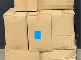 many boxes stacked on a pallet with a blue sticker
