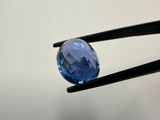 a close up of a blue diamond being held by a pair of pliers