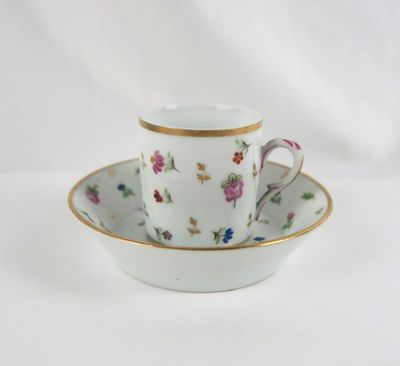 a cup and saucer on a saucer on a white table