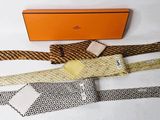 several ties are laid out on a white surface with a box in the background