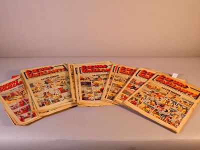 Plusieurs vieilles bandes dessinées sont alignées sur une table