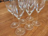 four empty wine glasses sitting on top of a wooden table