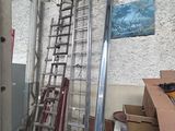 a ladder leaning against a wall next to a pile of boxes