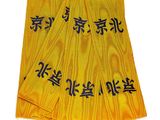 trois morceaux de tissu jaune portant des inscriptions en chinois, posés sur une surface blanche