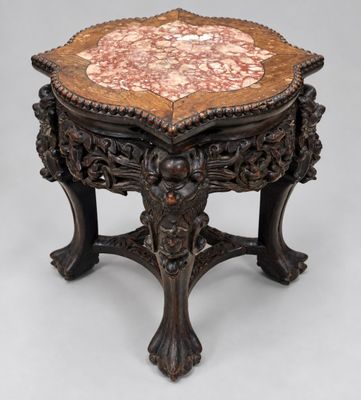 an ornately carved table with a marble top and wooden legs