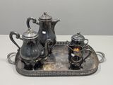 a silver tray with a silver tea set on it