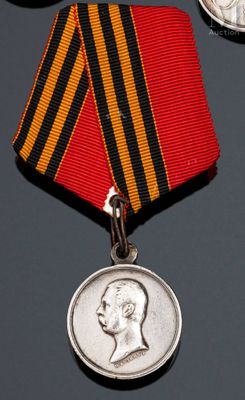 deux médailles et une médaille posée sur une table, à côté d'une pièce de monnaie