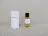 an image of a bottle of perfume next to a white container