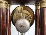 a clock that is sitting on a stand in the room