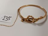 un gros plan d'un bracelet en or muni d'une chaîne, posé sur une table