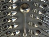 un grand nombre de cuillères et de fourchettes en argent disposées en cercle