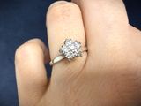 a woman ' s hand with a diamond ring on it