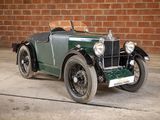 a green and black car parked in front of a brick wall