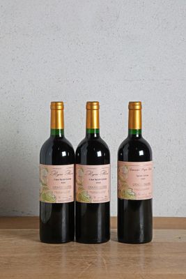 three bottles of wine sitting on top of a wooden table