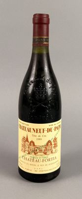 une bouteille de vin rouge posée sur une table à côté d'un verre de vin