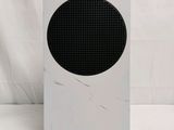 a white speaker with a black dot on it