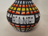 a vase with a colorful design on it on a table