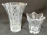 two glass vases sitting next to each other on a table