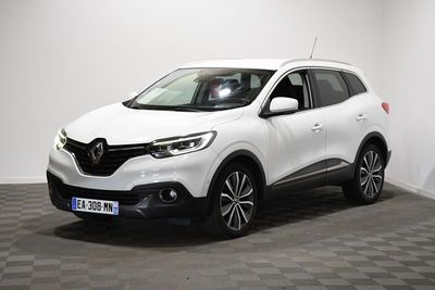 une voiture blanche est garée dans une pièce au sol à carreaux