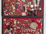 two wooden boxes filled with assorted jewelry on a red surface