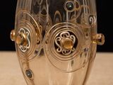 a glass cup that has a gold design on it