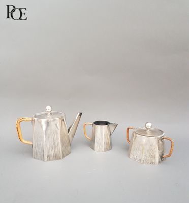 deux théières en argent et une cafetière posées sur une table