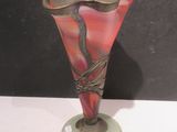 a glass vase with a bird on it on a table