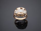 a gold ring with three diamonds on a black surface