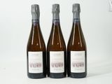 trois bouteilles de vin posées les unes à côté des autres sur une surface blanche