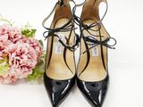 black heels with laces and a bouquet of flowers on a white surface