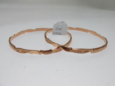 une paire de bracelets dorés ornés d'un motif gravé