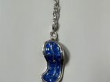 un collier en argent avec un visage bleu suspendu à une chaîne