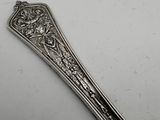 an antique silverware spoon with a design on the handle