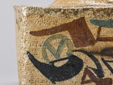 a close up of a vase with a bird on it