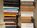 many books stacked on top of each other on the floor