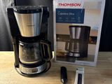 une cafetière posée sur une table à côté d'une boîte