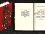 un livre rouge ouvert sur une surface noire